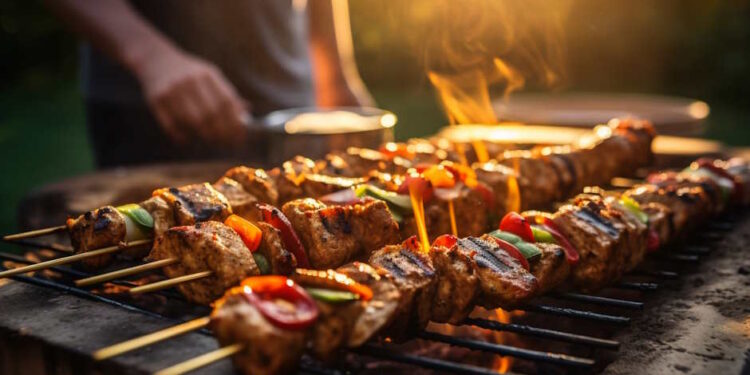 Сочные мясные шашлыки с овощами готовятся на открытом гриле под теплыми лучами солнца во время пикника - Moja Polska